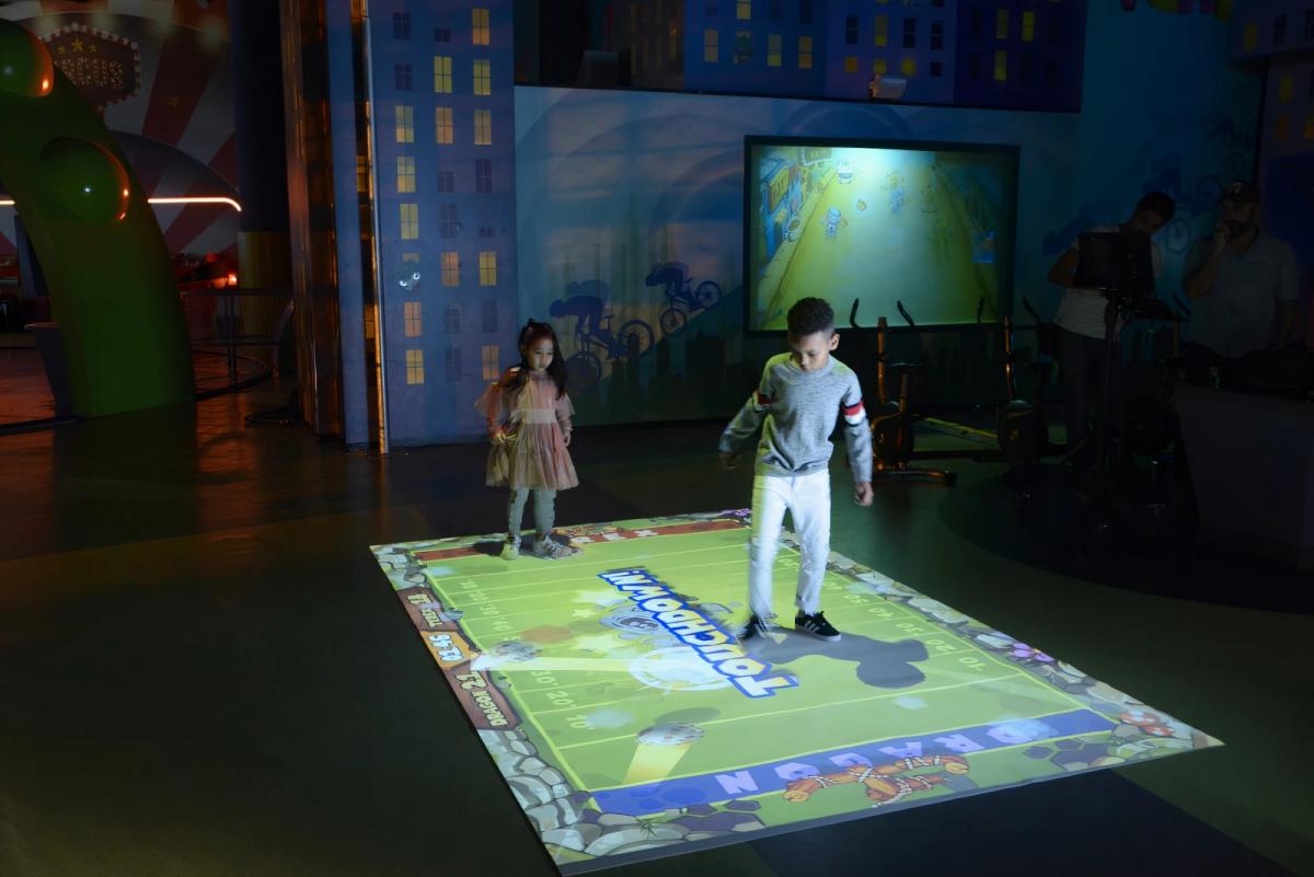 Children using an EyeClick interactive floor projection in an entertainment venue